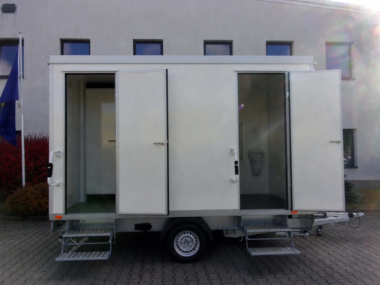 Toilettenanhänger Typ 2+1+2-37 mit geöffneten Sanitärtüren in Seitenansicht